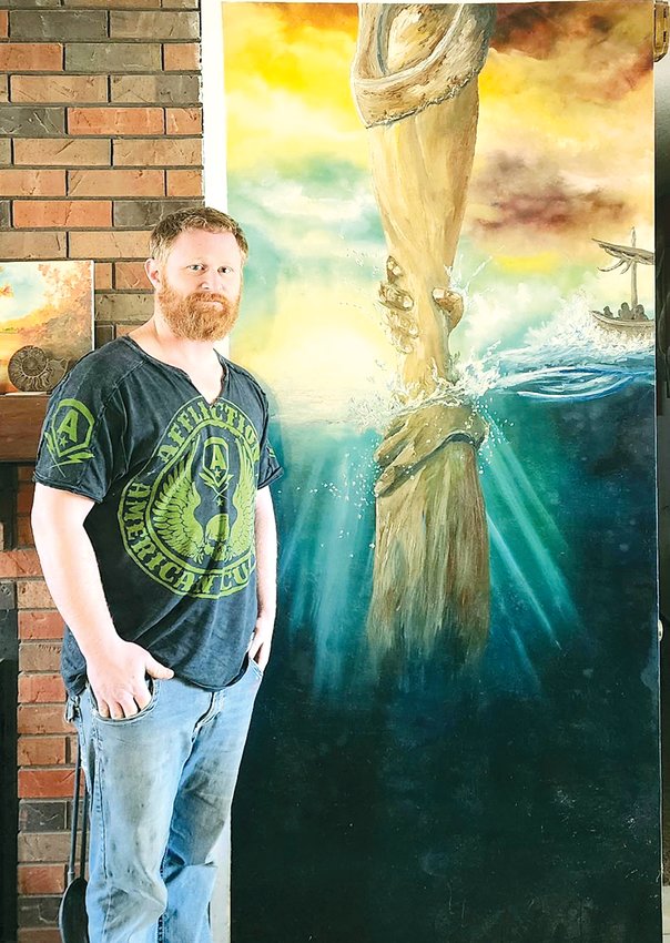 Thomas Laurent, who originally hails from Auburn, has been busy putting his artistic abilities to work this past year, creating stunning artwork like the one he is pictured with, which portrays the hand of God reaching into the water.