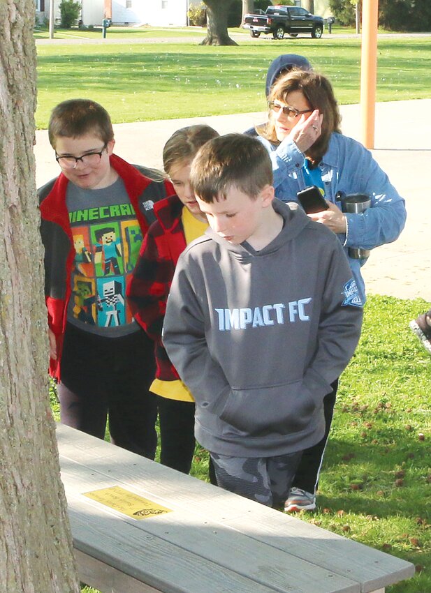 Raymond Grade School student Cody Matthews checks out the buddy bench donated by Project Third Day in honor of the late Darci Terneus during the unveiling of the benches on Friday, April 28.