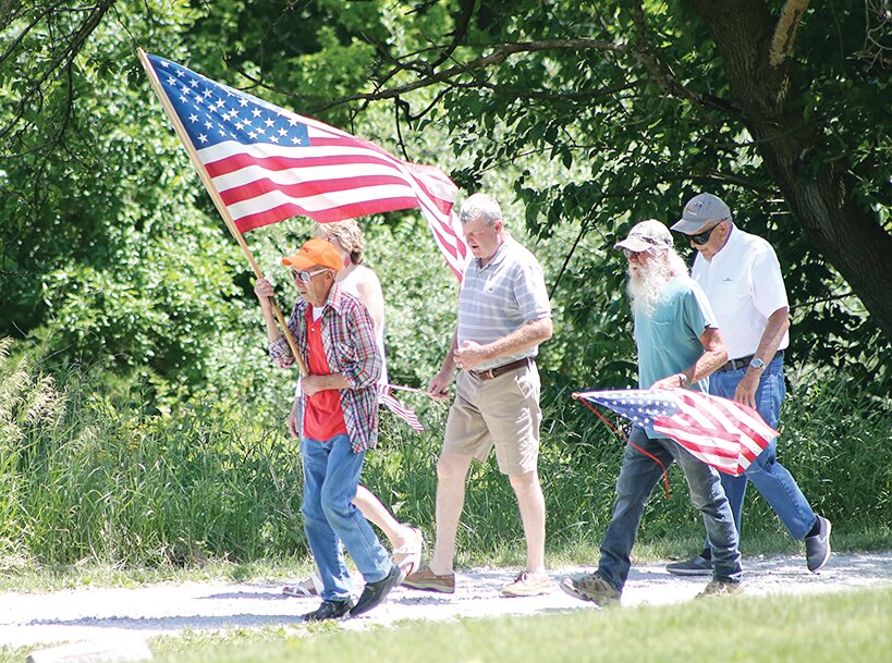 Frank Newberry carried the American Flag to lead the march from Irving United Methodist Church to the Irving Cemetery, a job he has performed for over fifty years.