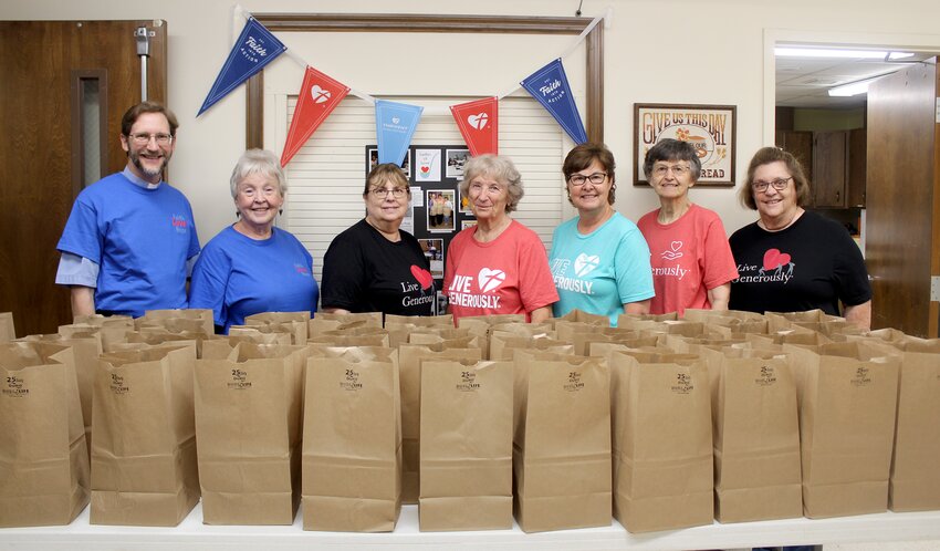 Ladles of Love celebrated its 12th anniversary by handing out to-go meals of fried chicken, mashed potatoes and gravy, coleslaw, rolls and cake on Wednesday afternoon, June 7. From the left, are volunteers Pastor Stefan Munker, Paula Keepper, Maribeth Rahe, Margarite Bolen, Lisa Finley, Carolyn Meier and Lori Evans.