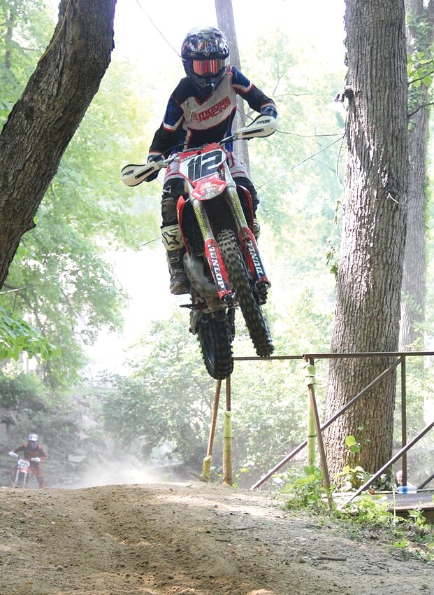 Gillespie racer Collin Johnson catches some air going over a hill near the bridge that crosses the creek at the Cahokia Creek Dirt Riders grounds in White City, during the Little Red Sprint Enduro on Sunday, June 4. Returning from a knee and ankle injury, Johnson took first in the AA class and was the overall winner of the event, beating friend and Morrisonville rider Jhadyn Walker by just 30 seconds in a race that lasts close to two hours.