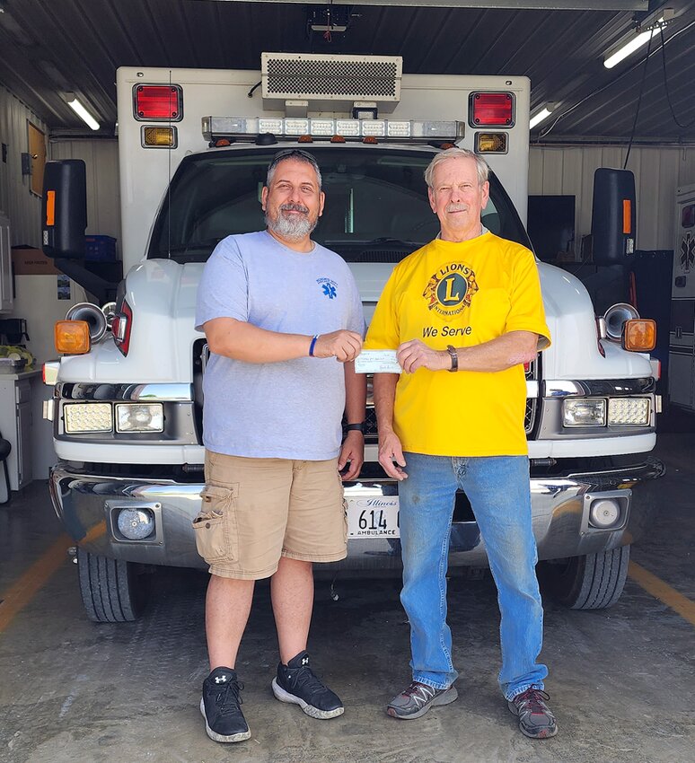 Gary Hulbert (right), representing Nokomis Lions Club, recently presented a donation to Chief Travis Hocq (left) in support of the Nokomis-Witt Area Ambulance Service.