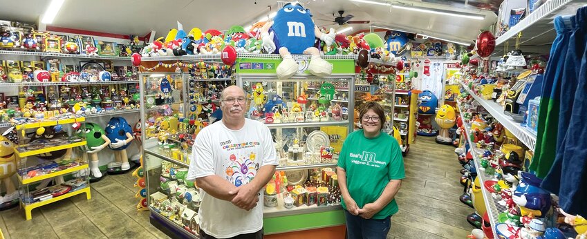 Steve and Patty Beal of Waggoner stand in front of the display cases at Beal's M&amp;M Museum, the culmination of almost 40 years of collecting M&amp;M memorabilia. While it's Steve's collection for the most part, Patty is an active participant as well, sometimes ordering items that she thinks may be a good fit for the collection. &quot;She's just as nuts as I am,&quot; Beal said. &quot;I admit I&rsquo;m an addict. She&rsquo;s in denial.&quot;