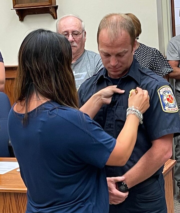 Katie Rogers pins her husband David&rsquo;s badge on after he was sworn in as the Litchfield Fire Department&rsquo;s newest captain on Thursday, July 6. Rogers has worked for the Litchfield Fire Department since 2011.