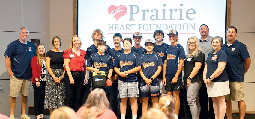 Above, the Rochester Junior High baseball team and Principal Kim Poole accept their AED machine from Prairie Heart Institute, the Prairie Heart Foundation and the McGraw family.