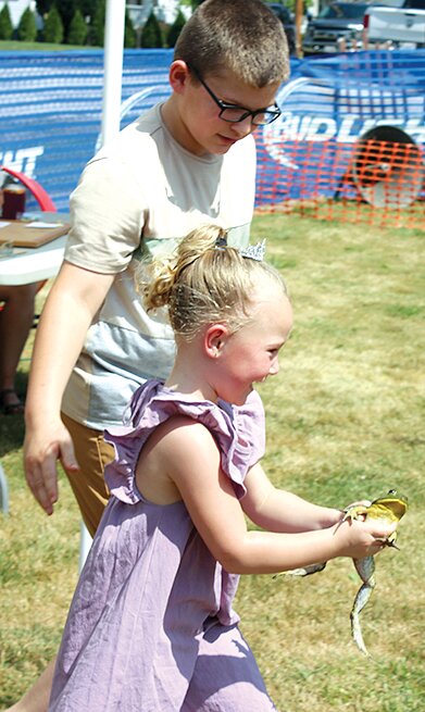 Little Miss Morrisonville Adeline Grundy gets some help from her big brother, Joe Grundy, during the 51st annual Bullfrog Jump at Morrisonville Homecoming and Picnic.