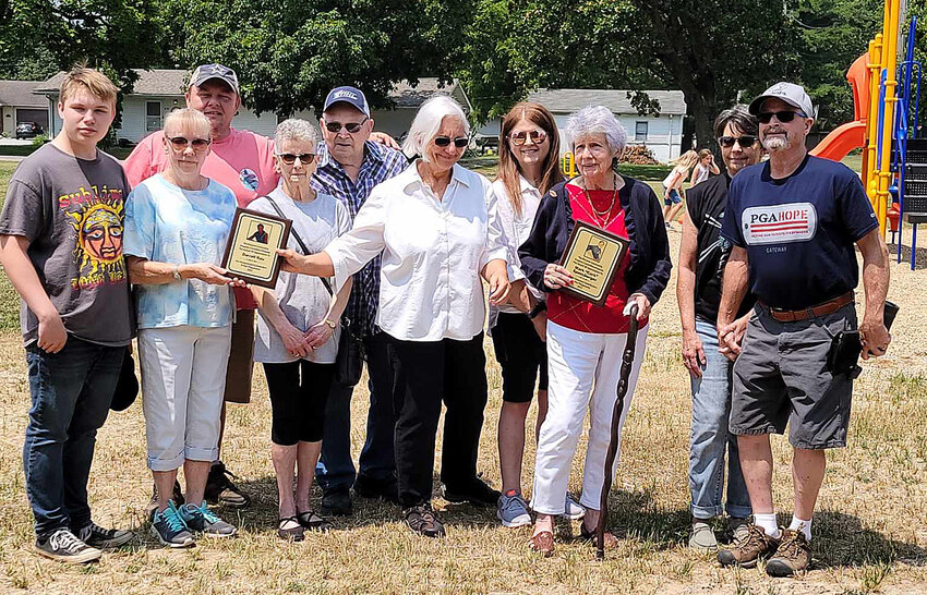The Panama Community Progress Committee presented plaques to several community members for their donations to purchase new playground equipment for John. L. Lewis Memorial Park. Above, committee member Dolly Knebel (center) presents memorial plaques to the families of Darrell Rau (left side) and Mark Spensberger (right side).