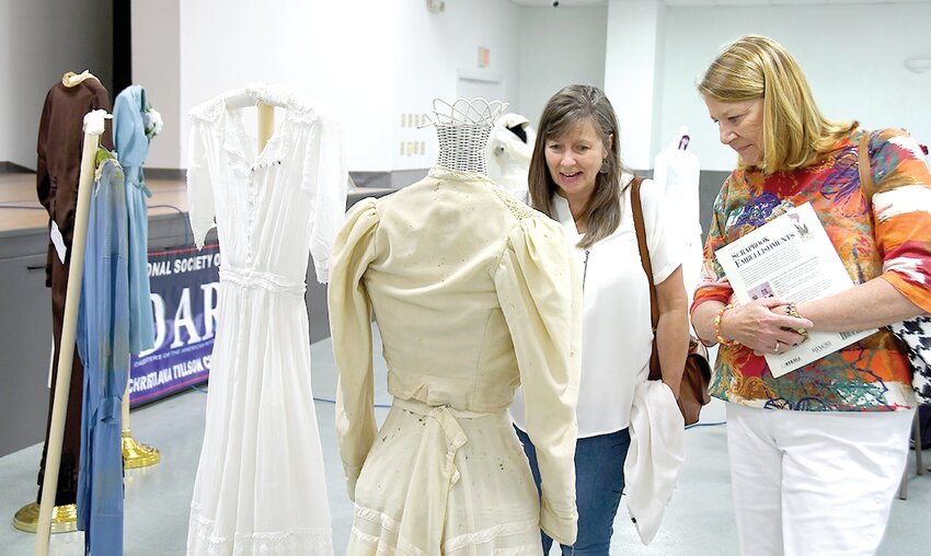 Pam Roberts, at left, and Sally Adams look at some historic wedding dresses as part of the &ldquo;Something Old, Something New&rdquo; program presented at The Event Center of Montgomery Center in Taylor Springs. The program was hosted by the Christiana Tilson chapter of the Daughters of the American Revolution.
