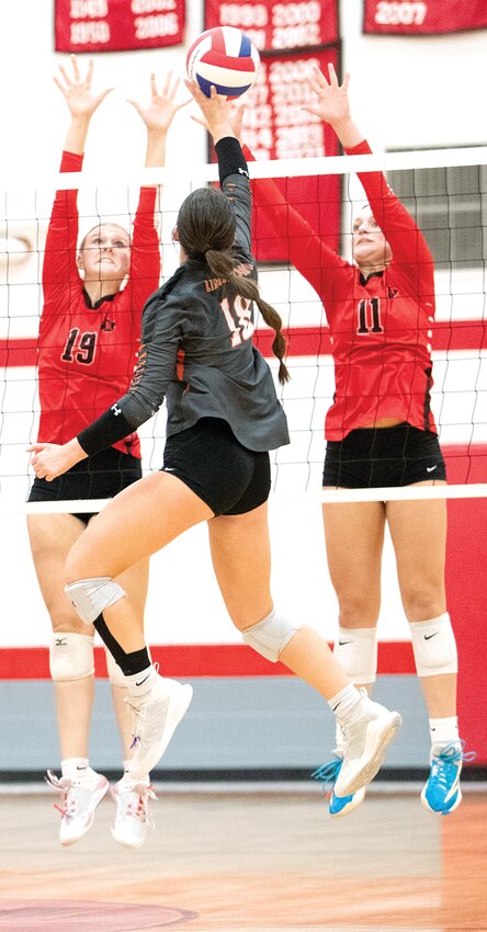 Lincolnwood's Morgan Cowdrey (#18) attempts to tip a shot past Nokomis' block of Reaghan Jonas (#19) and Mackenzie Mehochko (#11) during their MSM Conference clash on Tuesday, Sept. 26. Cowdrey had a team-high 12 kills in the Lancers' three-set victory over the Redskins that kept them undefeated in the conference.