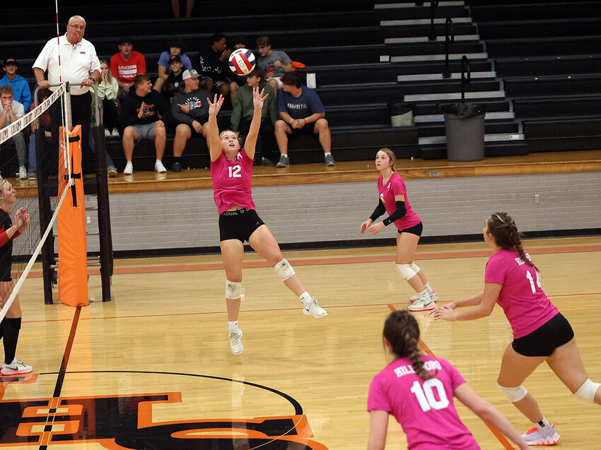Hillsboro senior Ellie Miller (#12) sets up Addison Lowe for the attack during the Toppers' home game on Oct. 5, against Staunton. The Bulldogs picked up their 38th straight win in the South Central Conference, beating the Toppers 25-10, 25-21.