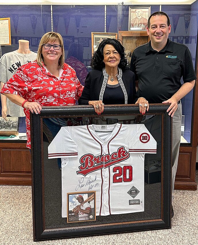 Pictured above, BRS president Lisa Billingsley, Jackie Brock and BRS treasurer Steve Johnson with a framed jersey donated from the Lou Brock Legends Collection.