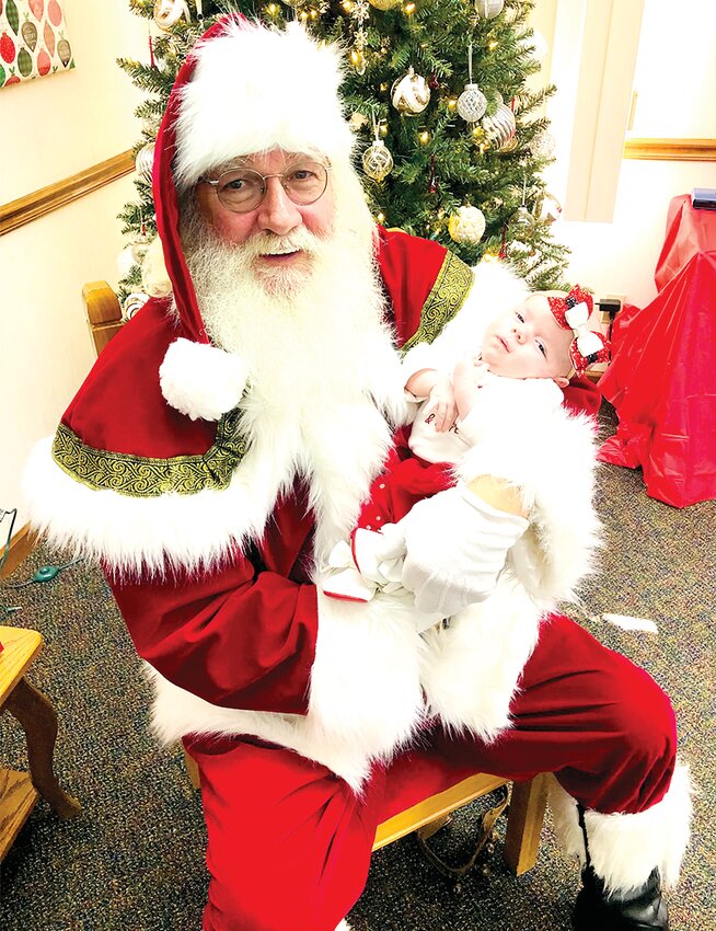 Ivy Jenkins met Santa for the first time, pictured above at Bank and Trust during the Raymond Christmas activities on Saturday, Nov. 25.Raymond-News Photo