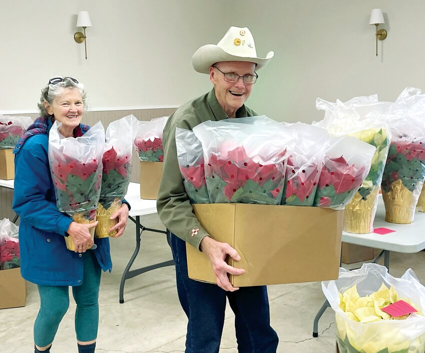 Pictured above, Sertoma member Bob Fuehne, at right, helps Merle Imler carry her poinsettias to her vehicle.