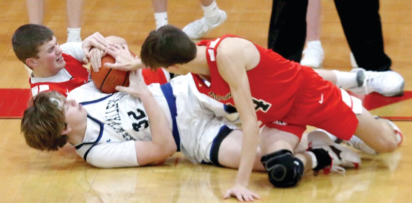 Nokomis&rsquo; Brody Steele and Reece Lohman try to wrestle the ball away from Wyatt Hildebrandt of Okaw Valley during the Redskins&rsquo; opening game at the Vandalia Holiday Tournament on Tuesday, Dec. 26. Lohman had 24 points for the Redskins helping them to a 63-54 victory over the Timberwolves.