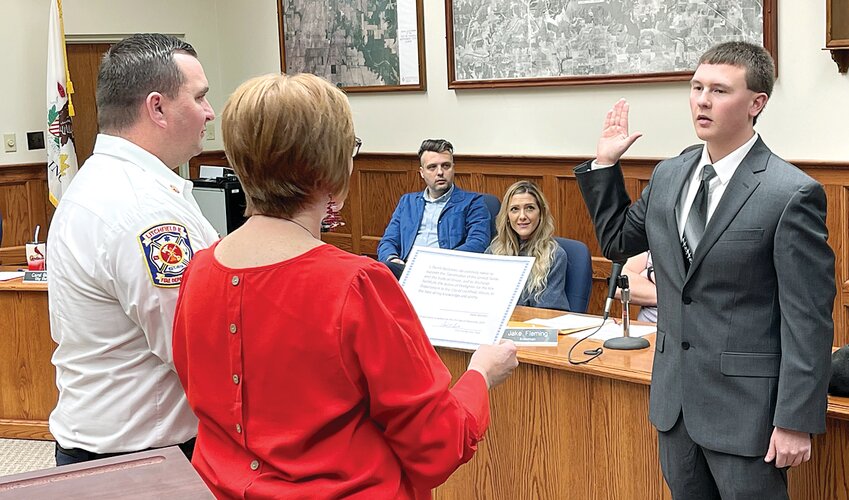 Derek Beckman, right, is sworn in by City Clerk Carol Burke and Fire Chief Adam Pennock as the newest member of the Litchfield Fire Department during the Litchfield city council meeting on Dec. 21. Beckman has almost literally grown up in fire houses across the area as his father Darin is the fire chief in Fillmore and branch chief for the central/west region of MABAS-IL.