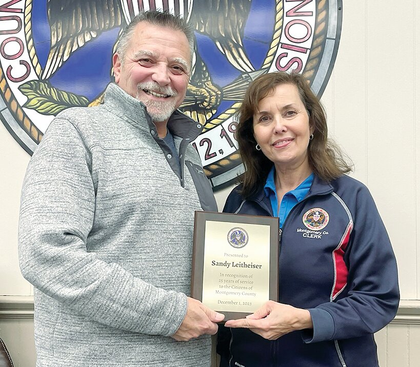 Montgomery County Board Chairman Doug Donaldson, at left, presents a plaque to Montgomery County Clerk and Recorder Sandy Leitheiser for 25 years of service to Montgomery County.