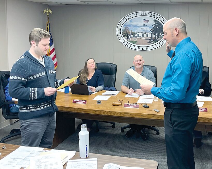 Hillsboro&rsquo;s city council paused long enough during Tuesday&rsquo;s meeting to hire Nathan Brown as the newest member of the police force. City Clerk David Jenkins, at left, did the ceremony. Brown, at right, born in Grand Tower, now lives in Pana, but is looking for housing for his family in Hillsboro; he brings 15 years police experience with him.