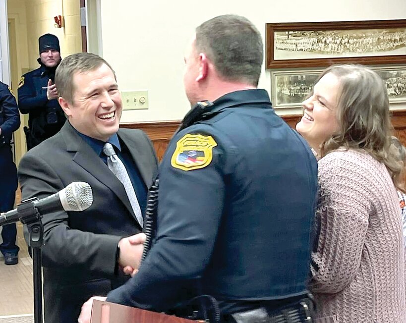 Litchfield native Lucas Ostendorf is congratulated by Police Chief Kenny Ryker after being sworn in as the newest member of the Litchfield Police Department by his wife Amber and Chief Ryker.