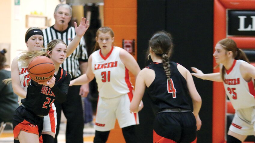 Guarded by Lincolnwood's Leah Anderson, with the Lancers' Lilly Terneus (#31) and Taylor Lush (#25) lying in wait, Hillsboro freshman Amya Greenwood gets ready to pass to teammate Kamryn Langston (#4) during the second half of the Toppers' game at the Woodshed in Raymond. After a slow start, Greenwood, Langston and the rest of the Hiltoppers rallied to turn a 15-13 halftime lead into a 52-25 win over the Lancers.