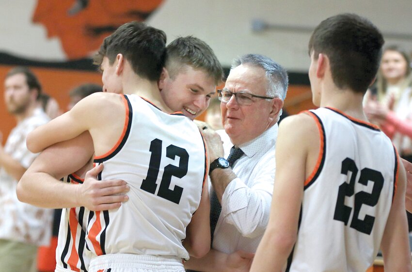 Lincolnwood&rsquo;s Gabe Armentrout is congratulated by his brothers, Tucker (#12) and Luke (#22), and Assistant Coach Bill Krager after scoring against Ramsey in the opening seconds of the Lancers&rsquo; game in Raymond on Tuesday, Jan. 30. Armentrout was scheduled for surgery to repair a torn ACL the following day, but an agreement between Lincolnwood Head Coach Matt Millburg and Ramsey Head Coach Jeff Babbs allowed the senior one last opportunity to make a basket and come off the court for the Lancers.