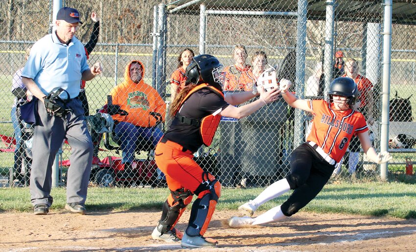 Beating the throw from the outfield to Lincolnwood-Morrisonville catcher Kaci Bethard, Hillsboro&rsquo;s Audrey Shultz slides into home plate for the Lady Hiltoppers&rsquo; eighth run of the game. Hillsboro went on to score two more after Shultz&rsquo;s sprint to the plate as they defeated the Lady Lancers 10-5 in Hillsboro on Monday, March 11.