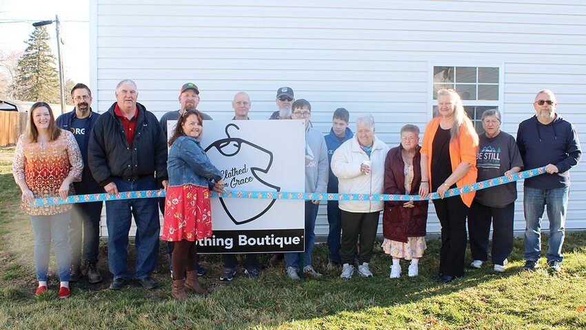 Community and church members celebrated the opening of Clothed In Grace, a free clothing boutique ran by Raymond Baptist Church. Pictured above, from the left are Tiffany and Daniel Johnson, Mayor Denny Held, Tammy Butler, cutting the ribbon, Jeremy Cray, Kevin Ford, Harold Cantrall, Lee and Jacob Johnson, Mary Cantrall, Donna Elliott, Angel Kellow, Sherry Lewey and Pastor Ron Butler.