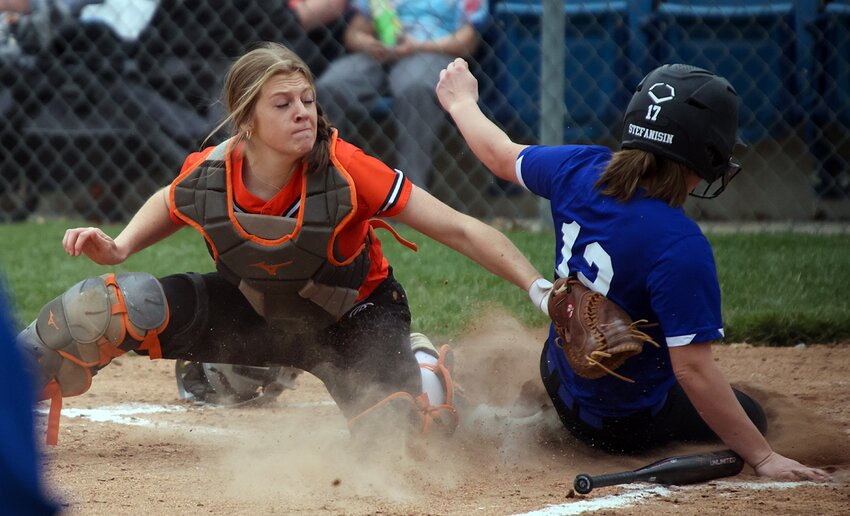 Hillsboro catcher Sophia Blankenship tries to get the tag down on Greenville's Ramzi Stefansin during the Toppers' trip to Greenville on Friday, March 22. The Comets scored three runs in the fifth and four more in the sixth to break a 3-3 tie and collect a 10-3 non-conference win over the Toppers.