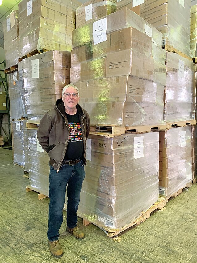 Steve Schmidt of Love Packages in Butler is dwarfed by just one of several stacks of shrink-wrapped skids ready for shipping.