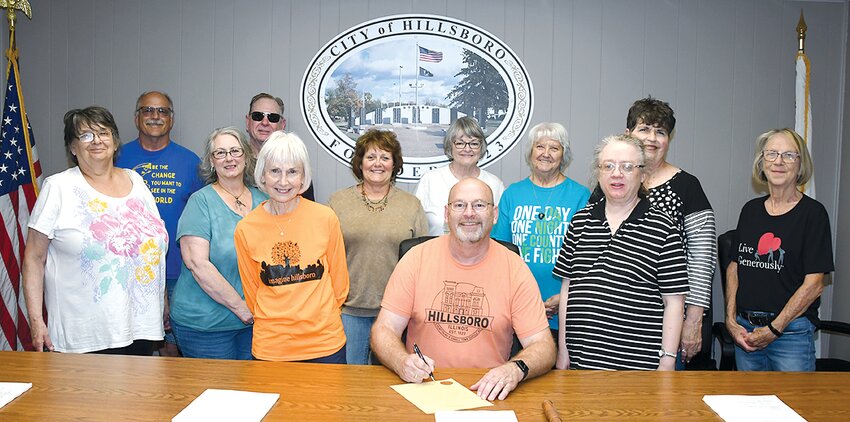 Hillsboro Mayor Don Downs signs a proclamation for National Volunteer Week at Hillsboro City Hall on Tuesday afternoon, April 16. Pictured above, in front, from the left are Lyn Fugate, April Leetham, Anne Huber, Hillsboro Mayor Don Downs and Carol Herrin. In back are Bob Schwandner, Doug Johnson, Ginger Barnes, Nancy Hindle, Mable Murray, Pam DeLong and Janece Neunaber.