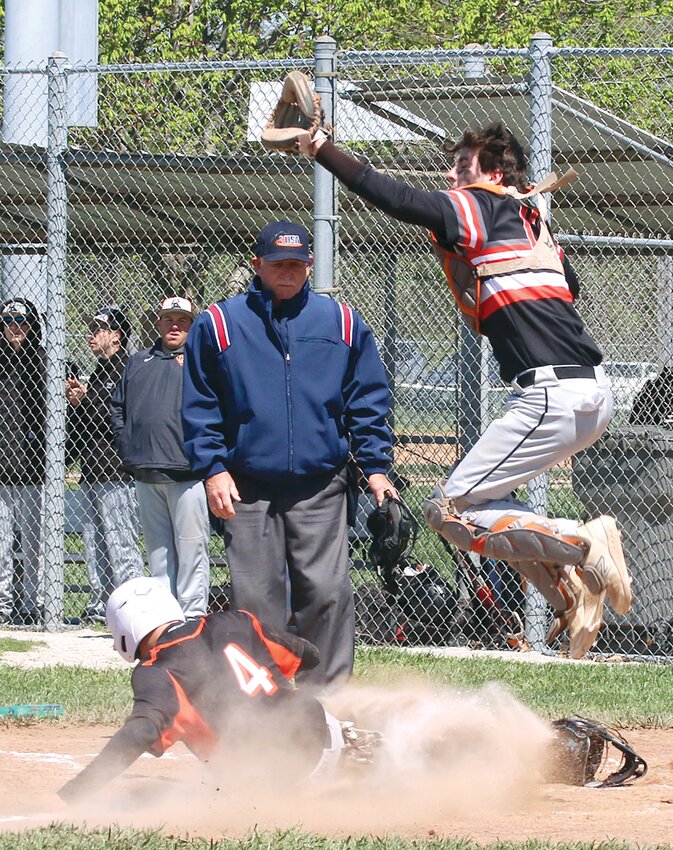 Hillsboro catcher Landon Summers jumps to snag a high throw and avoid Lincolnwood's Brodey Vanhooser as the sophomore from Morrisonville slides into home plate during the second inning of the game on Saturday, April 20. Vanhooser's run was one of 11 in the inning for Lincolnwood, who defeated the Toppers 13-0 in five innings.