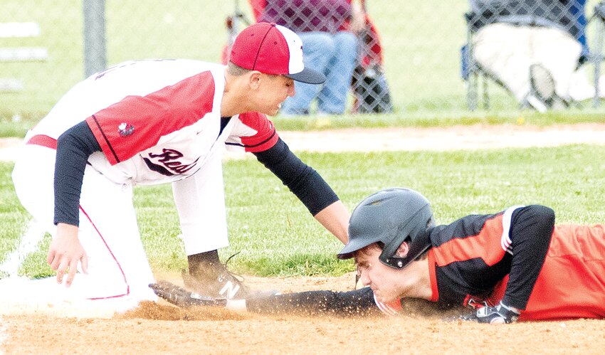 Hillsboro's Nathan Matoush dives back into first ahead of the tag by Nokomis' Bryce Gillock during the county showdown in Nokomis on April 25. A little later, Matoush got the final two outs in the Toppers' 4-2 win over the Redskins.