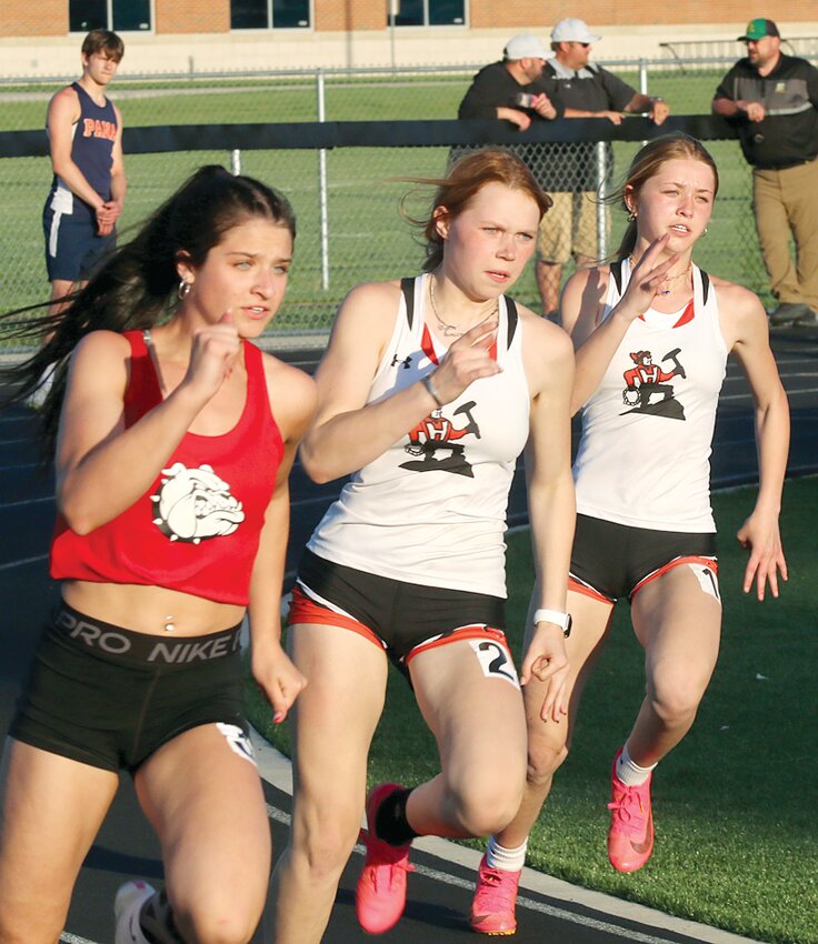 Staunton's Lilly Trettenero and Hillsboro's Samantha Page (center) and Amya Greenwood  were in perfect sync going around the first turn during their heat of the 200 meter dash at the South Central Conference Championships on Tuesday, April 30, in Virden. Page finished second in the event, one of 11 top six finishes for the Toppers, while Greenwood was seventh by a hundredth of a second. Greenwood had her moment earlier in the day, taking first in the triple jump.
