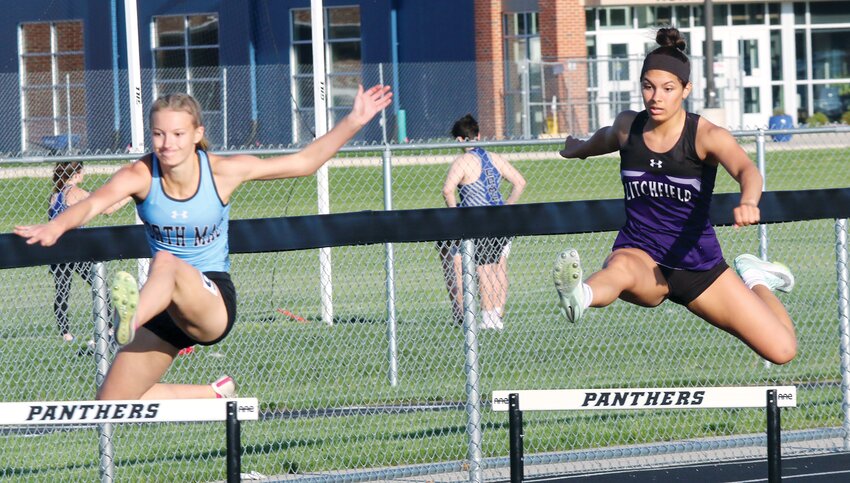 Litchfield's Kendall Stewart (right) and North Mac's Emma Crawford leap over a hurdle during the 300 meter hurdle race at the South Central Conference Championships on Tuesday, April 30, in Virden. Stewart, who played a part in 36 of Litchfield's 56 points, finished second to Crawford in the event, running a 50.43.