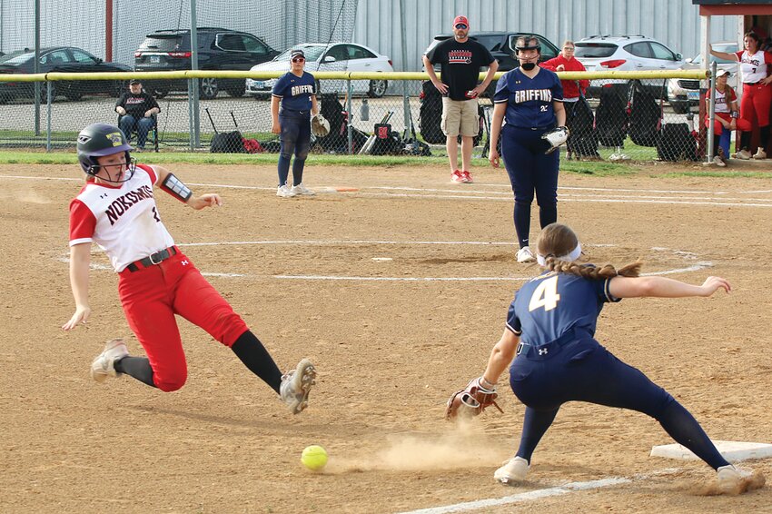 The throw from the catcher skitters past the glove of Father McGivney shortstop Julia Behrmann and the left foot of Nokomis' Cloey Dirks during the bottom of the fourth inning of the Lady Redskins' home game on May 3. Dirks, who stole second earlier, didn't spend long on third as she stole home for one of Nokomis' 14 runs in their 14-7 win over the Griffins.