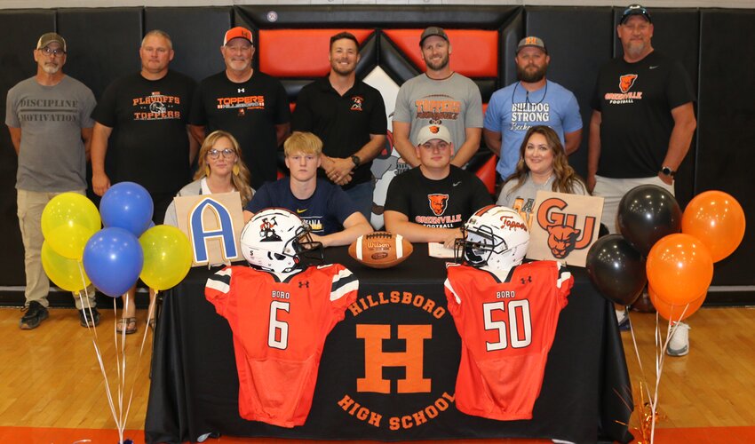 On Monday, May 13, friends and teammates Zander Wells and Cole Lenczycki took the next step in their educational and athletic journeys as they signed to play football at Augustana College and Greenville University, respectively. Seated are Zander Wells (#6) with mom, Haley Wells, and Cole Lenczycki (#50), with mom, Jenny Lenczycki. Standing are football and wrestling coach Aaron Shultz, Wells' father Mike Wells, football coach Bill Reed, head wrestling coach Garrett Young, head football coach Joe Reed, football coach and head track coach Zach Reed and Lenczycki's father, Jason Lenczycki.