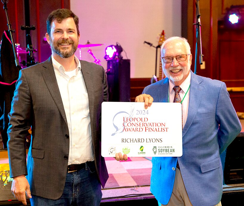 Lance Irving, of the Sand County Foundation, gives a 2024 Illinois Leopold Conservation Award Finalist award to Richard Lyons, of Montgomery County, Sunday night July 14. The top 3 finalists for the award were honored during the Association of Illinois Soil &amp; Water Conservation Districts