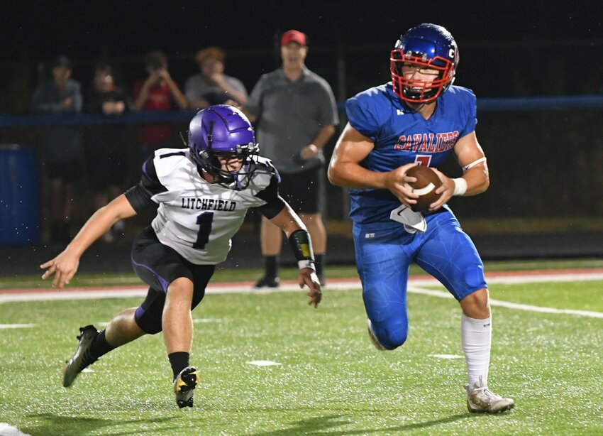 Carlinville quarterback Noah Byots tries to elude Litchfield's Isaiah Johnson (#1) on the rain-soaked turf at Carlinville High School during the week one South Central Conference match-up between the Panthers and Cavaliers. The Litchfield defense managed to put some pressure on Byots and the Cavies, but Carlinville did the same on the other end, picking off four passes, posting four sacks and holding Litchfield to two scores in a 37-12 week one victory.