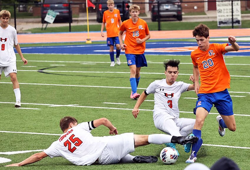 Hillsboro's Brady Stritzel (#25) and Nico Clark (#3) meet up at the feet of Riverton's Jaxson Miller (#20) during the Toppers' game on the Hawks' home field in Riverton. Clark had three goals in Hillsboro's 6-1 victory, their 11th in a row.