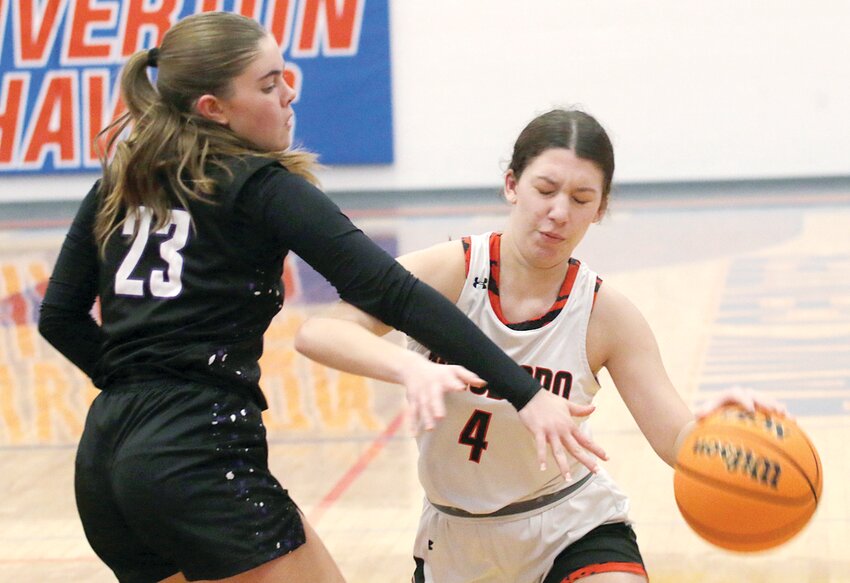 Mt. Pulaski's Claire Bobell reaches in on Hillsboro's Kamryn Langston during their championship quarterfinal game at the Riverton Christmas Classic on Thursday, Dec. 26. Hillsboro went on to beat the fourth-seeded two-L'ed Hilltoppers 59-49, en route to a fourth place finish at Riverton.