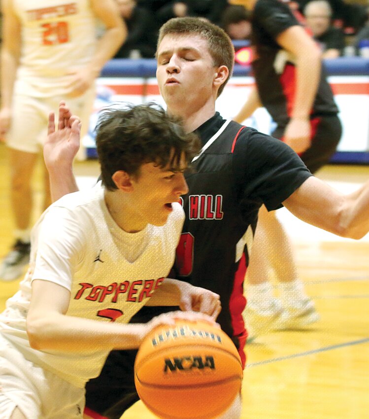 Hillsboro's Tony White tries to drive past Will Manar of Bunker Hill during the fifth place game at the Carlinville Holiday Tournament on Saturday, Dec. 28. The Toppers picked up a 58-50 victory over the Minutemen, their eighth win of the season.
