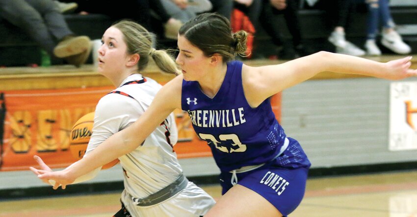 Hillsboro's Amya Greenwood tries to maneuver past Greenville's Adyson Bearley (#23) during the first half of the Toppers' home game on Monday, Feb. 10. Greenwood finished with 17 points, one of four players to reach double figures in Hillsboro's 69-45 victory over the Comets.