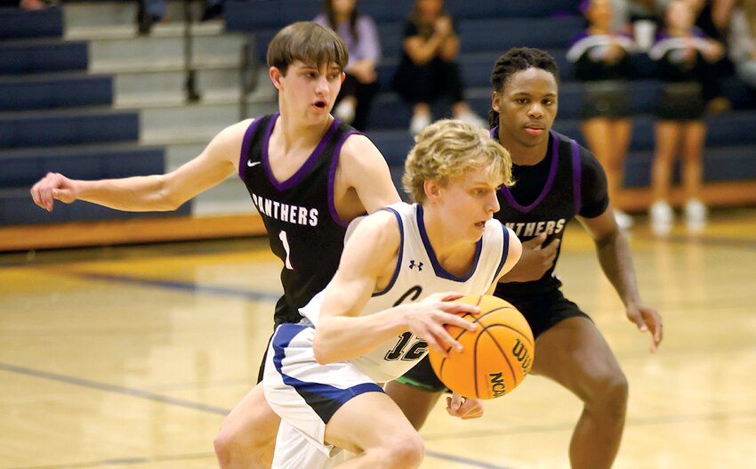 Greenville's Gus Olson tries to slip past Litchfield defenders Keenan Logan (#1) and Martavious Jones during the regional semifinal on the Comets' home floor on Wednesday, Feb. 26. Olson had seven points in a close 43-34 victory that ended Litchfield's season with a 15-18 record.
