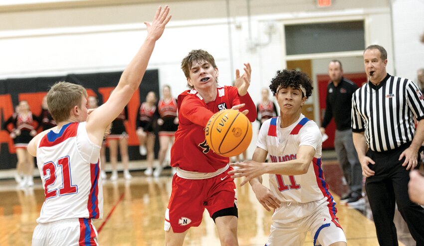 Nokomis senior Ian Keller threads a pass between St. Anthony defenders Will Fearday and Keenan Griffith during the regional semifinal game in Moweaqua on Wednesday, Feb. 26. The Bulldogs ended Nokomis' season with a 45-23 victory, en route to picking up their third regional championship in four years.