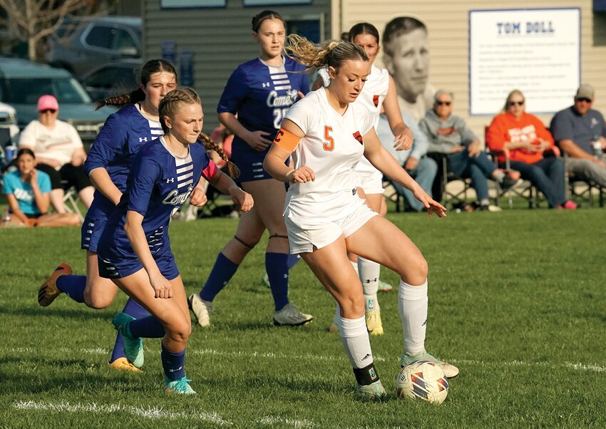 Hillsboro senior Reagan Lentz draws a crowd of Comets during the Toppers' game in Greenville on Thursday, April 17. Down 1-0 at halftime, Hillsboro got the equalizer from Lentz ten minutes into the second half on a hard shot that deflected off the Greenville keeper. Unfortunately, the Comets got the go-ahead goal on a penalty kick four minutes later and held on for the 2-1 win.