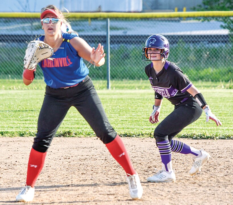 Litchfield's Kinley Hemken takes a trepidious lead off first behind Carlinville's Isabella Tiburzi after the pitch to home during the Lady Panthers' home game on Monday, April 28. Hemken's walk was one of four allowed by Carlinville, but the combo of Hallie and Hannah Gibson held the Panthers to just one hit in a 7-0 victory.