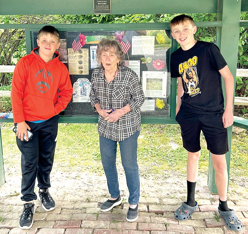 Sonya Luckett finishes up the Bremer Sanctuary Bulletin Board for the month of May alongside her great-grandsons, Wes (left) and Wyatt (right).