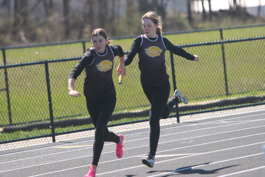 Lone Tree’s Cate Sexton hands off the baton to Vivian Zaruba at West Branch on April 6.