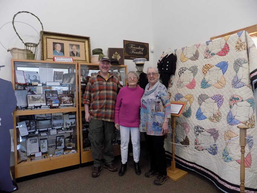 Locke Peterseim (left), Jan Peterseim (middle), and Julie Zahs (right) stand in the center of the Founding Families exhibit they created based on family photos and stories, as well as newspaper archives, pertaining to Rollie and Barb Peterseim.