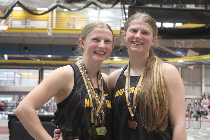 Mid-Prairie freshman Jeorgia Evans (left), with four IATC medals dangling around her neck following a record day, poses for a photo with older sister and teammate Jovi Evans. They both ran in the 4x100.