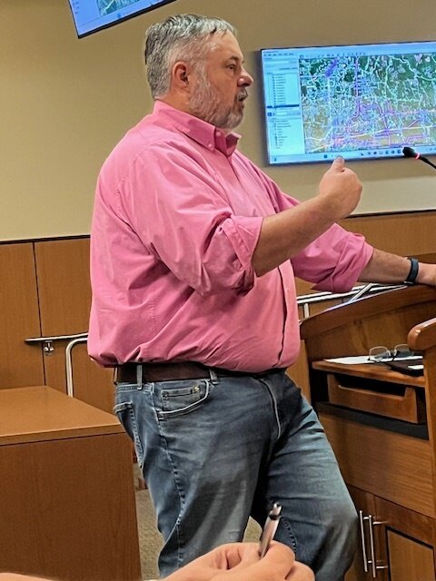 Ralph Burgess, member of the Livingston Parish Infrastructure Committee, as he presents a long-range plan for road and street construction and improvements at the first-ever meeting of the infrastructure committee on Thursday. In the background is a TV screen on which was projected a map of the parish on which Burgess highlighted plans for road construction.